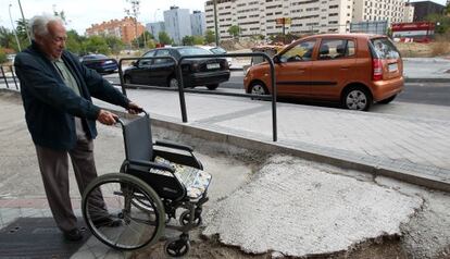Jesús Martínez, con la silla de ruedas de su esposa junto a la acera construida en 2011.