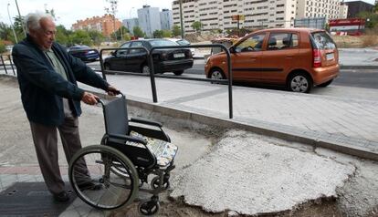 Jes&uacute;s Mart&iacute;nez, con la silla de ruedas de su esposa junto a la acera construida en 2011. 