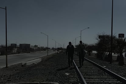 Misioneros religiosos caminan por las vías del ferrocarril en Villa Ahumada, una localidad golpeada por la violencia.