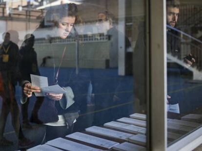 Una mujer elige papeletas en un colegio electoral de Barcelona.