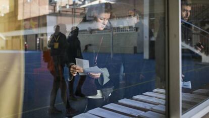 Una mujer elige papeletas en un colegio electoral de Barcelona.