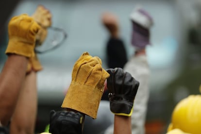 Miembros de las brigadas de rescate y voluntarios levantan sus manos para pedir silencio absoluto mientras continúan escarbando de forma manual en las ruinas de una escuela en el sur de Ciudad de México (México).