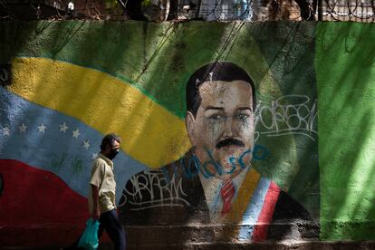Un hombre camina frente a un mural de Maduro, en Caracas.