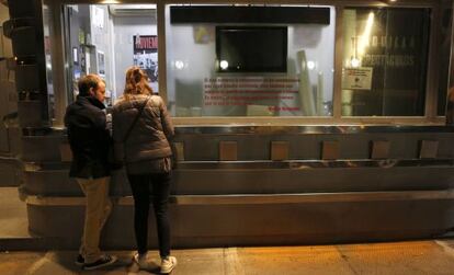 Dos espectadores, ante la taquilla de una sala de cine madrileña.