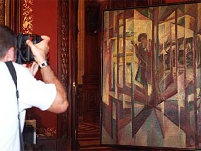 Un fotógrafo dispara su cámara ante <i>La puerta giratoria</i>, de Guezala, ayer, en la Diputación de Vizcaya.
