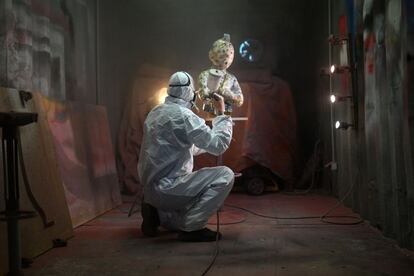 Un empleado barniza una obra de arte que representa el personaje de Tintín del artista plástico Christophe Tixier, alias "Peppone", en su taller de La Roque d'Antheron, en el sur de Francia.