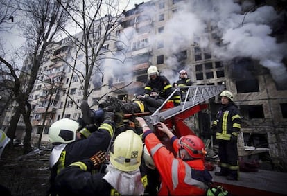 Los bomberos evacuaban a vecinos de un bloque de viviendas bombardeado en Kiev el 14 de marzo.