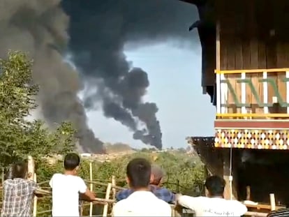 Varias personas observan columnas de humo en Hkamti, en la región birmana de Sagaing, en una imagen difundida este sábado en las redes sociales.