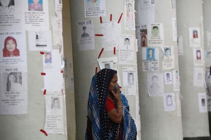 Una mujer espera noticias rodeada de carteles de desaparecidos.