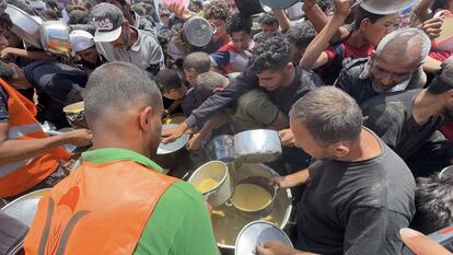 Palestinos, en su mayoría, niños, esperan comida distribuida por organizaciones benéficas mientras Gaza sufre duramente el bloqueo israelí, en Ciudad de Gaza, este jueves. 
