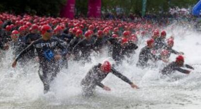Participantes en el triatlón se zambullen en el agua al inicio de la prueba
