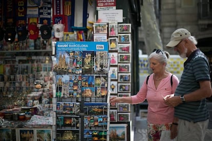 25/06/19 Dos turistas miran postales en un quiosco de la Rambla. 