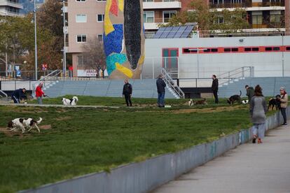 Varias personas pasean a sus mascotas en parque de Joan Miró de Barcelona. 