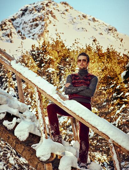 Gafas con montura dorada y cristal marrón de Givenchy para Sáfilo, jersey de cuello alto en mohair gris de Dior Homme, y chaleco de punto, pantalón de tweed y botas de montaña color caldera, todo de Missoni. 