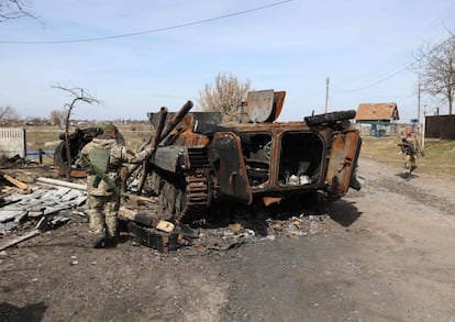 Soldados ucranios examinan los restos de un vehículo blindado de transporte de personal ruso destruido en la línea del frente en el norte de la región de Kiev, este lunes. 