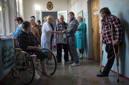 Una enfermera del hospital de Mariupol vota en una urna m&oacute;vil ante la mirada de los pacientes del hospital.