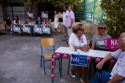 Partidarios del 'Si' y del 'No' esperan la llegada de votantes en un centro de votaciones en Atenas (Grecia).