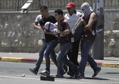 Un grupo de palestinos trasladan a un compañero herido durante los enfrentamientos con las fuerzas de seguridad israelíes en Jerusalén.