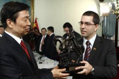 Fotografía cedida por prensa del Ministerio de Relaciones Exteriores de Venezuela donde se observa al vicepresidente de Venezuela Jorge Arreaza (d), entregando un obsequio al vicepresidente chino, Li Yuanchao (i).