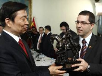Fotografía cedida por prensa del Ministerio de Relaciones Exteriores de Venezuela donde se observa al vicepresidente de Venezuela Jorge Arreaza (d), entregando un obsequio al vicepresidente chino, Li Yuanchao (i).