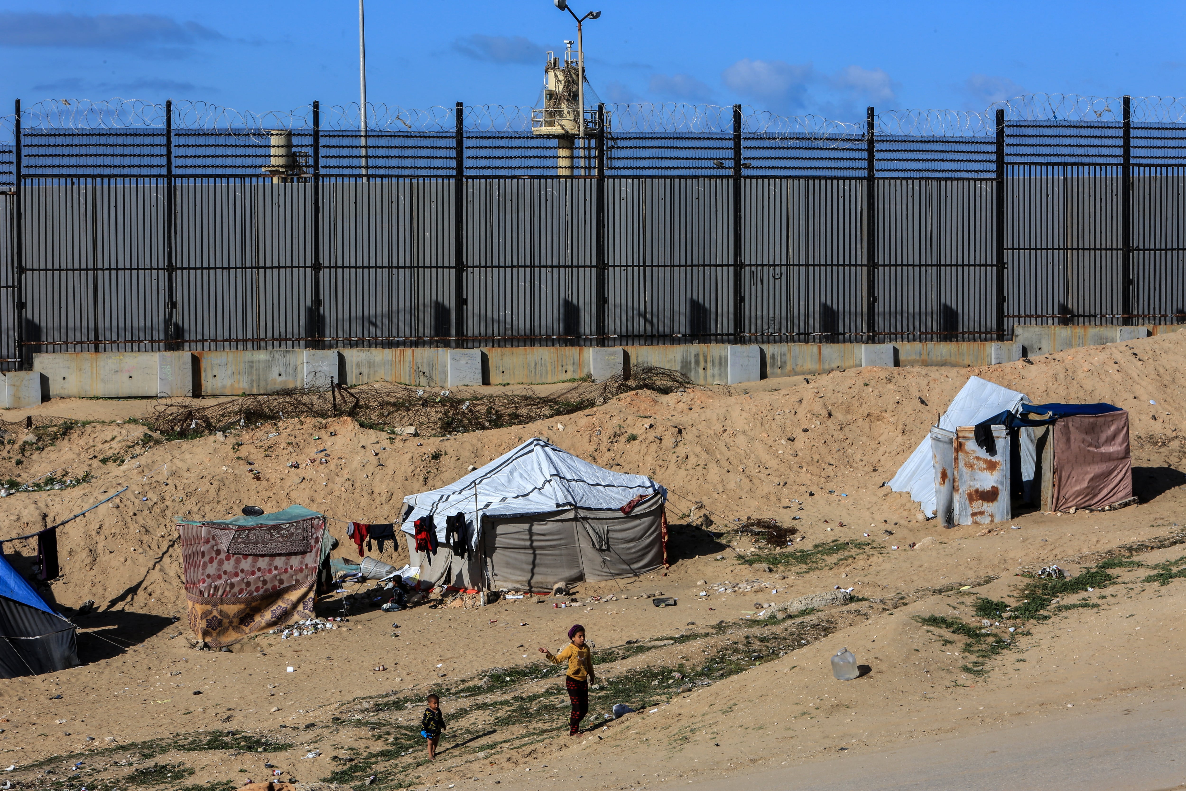 Unos niños palestinos juegan cerca de la frontera entre Egipto e Israel, en una foto tomada en marzo de 2024.