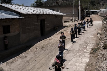 La hilera de soldados de cabello negro y piel oscura desfila por el pueblo. Llevan gorra de visera y calzan huaraches de cuero rígido. Con un paliacate atado al cuello se cubren la nariz y la boca, como si fueran guerrilleros marchando al combate.