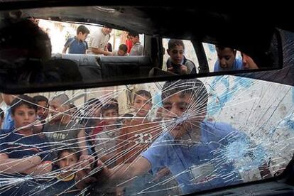 Un grupo de niños observa un coche de Hamás tiroteado en los enfrentamientos con milicias de Al Fatah, ayer en Gaza
