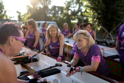 Las mujeres se preparan junto a los barcos antes del entrenamiento.