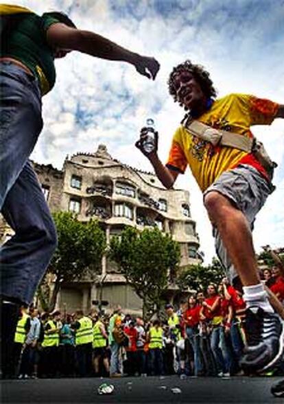 Unos jóvenes bailan ante La Pedrera durante la <i>Carnavalona</i> que se celebró ayer en Barcelona.
