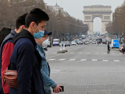 Turistas usam máscaras de proteção na avenida Champs Elysees, em Paris, no dia 17 de março.