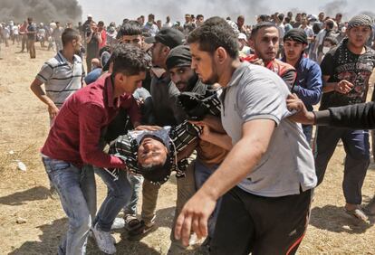 Un palestino herido es trasladado por otros manifestantes durante los choques entre palestinos y las tropas israelíes en la franja de Gaza, el 14 de mayo de 2018.