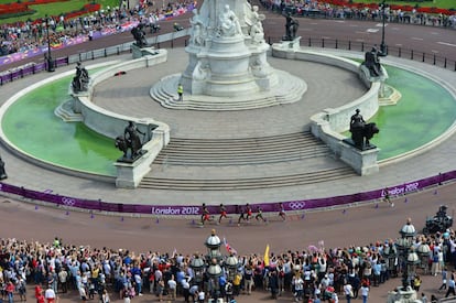 El público se agolpa alrededor del monumento dedicado a la Reina Victoria para presenciar el paso de los atletas.