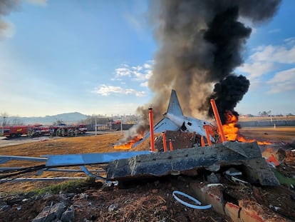 Imagen proporcionado por los Bomberos de Muan donde se muestra los restos del avin tras el accidente, este domingo en el aeropuerto de Muan. 