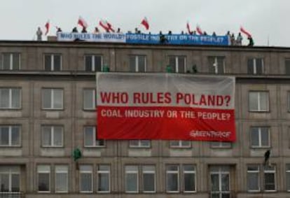 Activistas de Greenpeace despliegan desde el tejado del Ministerio de Economía pancartas con el mensaje "¿Quién gobierna Polonia? ¿La industria del carbón o el pueblo?", durante una protesta, hoy, en Varsovia (Polonia).