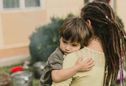 Una madre abraza a su hijo.