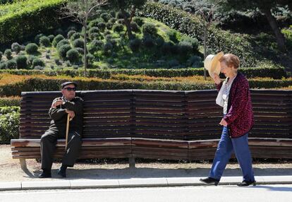 Dos jubilados toman el sol en la zona de Madrid Río.