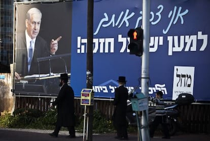 Dos ultraortodoxos caminan cerca de un cartel electoral de Netanyahu en Ramat Gan, cerca de Tel Aviv.