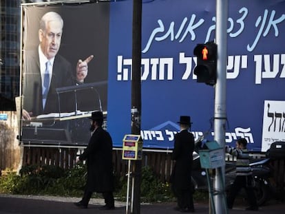 Dos ultraortodoxos caminan cerca de un cartel electoral de Netanyahu en Ramat Gan, cerca de Tel Aviv.