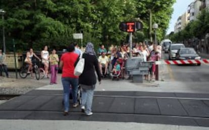 Una mujer con un carrito cruza la vía en Salou pese a que lo impide la señal luminosa