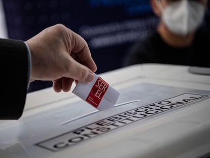 Un miembro del Servicio Electoral muestra cómo emitir su voto en un colegio electoral antes del referéndum en Santiago, Chile.