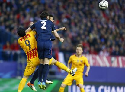 Los jugadores Godin y Suárez intenta golpear el balón de cabeza.