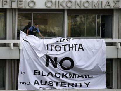 Seguran&ccedil;a tira faixa em protesto contra a austeridade, em Atenas. 