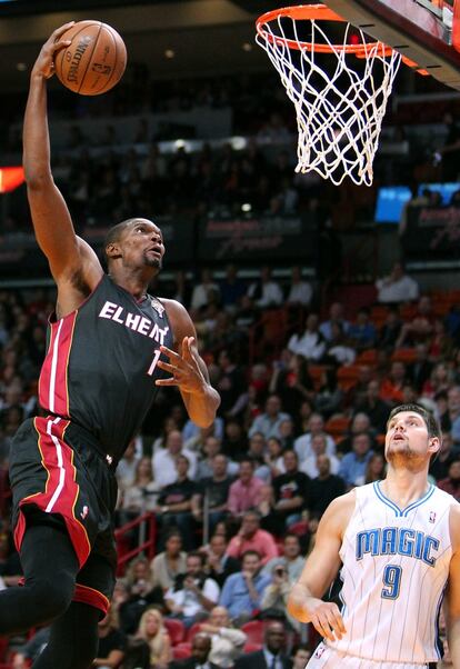 Chris Bosh, observado por Nikola Vucevic, se dispone a hacer un mate.