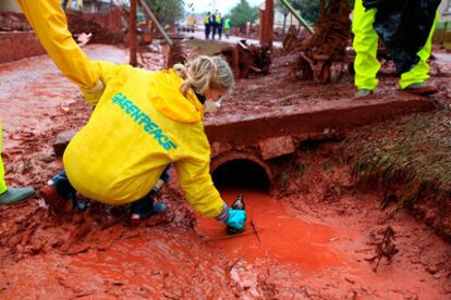 Una activista de Greenpeace toma muestras del vertido tóxico cerca de Ajkai, en una fotografía proporcionada por la organización ecologista.