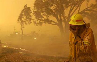 Un bombero se cubre ante el avance del fuego en Camberra.