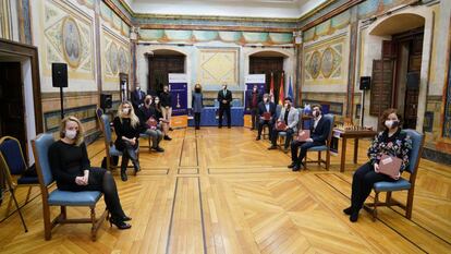 Los ocho partticipantes, sentados, junto al árbitro, organizadores y patrocinadores, al fondo