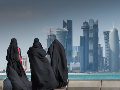 Tres mujeres árabes observan el skyline de Doha, en Qatar.