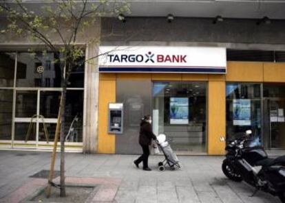 Una mujer pasando por delante de una oficina de Targobank