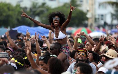 Decenas de personas asisten al espectáculo de apertura del precarnaval de Río de Janeiro 2020, este domingo en la playa de Copacabana, en Río de Janeiro (Brasil). Durante la jornada desfilaron las primeras comparsas callejeras y se eligió al rey Momo, una figura emblemática que, por primera vez, recibió las llaves de la ciudad un mes antes del inicio oficial de la fiesta.