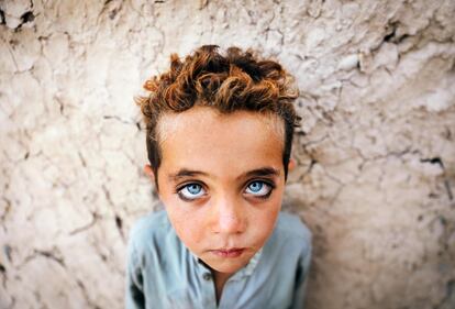 Un niño afgano llamado Montazer, de cuatro años, posa para una fotografía mientras trabaja en un horno de ladrillos, en las afueras de Kabul, Afganistán. Los trabajadores, la mayoría de los cuales trabajan descalzos y sin guantes, y alguno de los cuales no ha cumplido cinco años, ganan de tres a siete dólares estadounidenses al día dependiendo de sus horas de trabajo y de la cantidad de ladrillos que fabriquen.